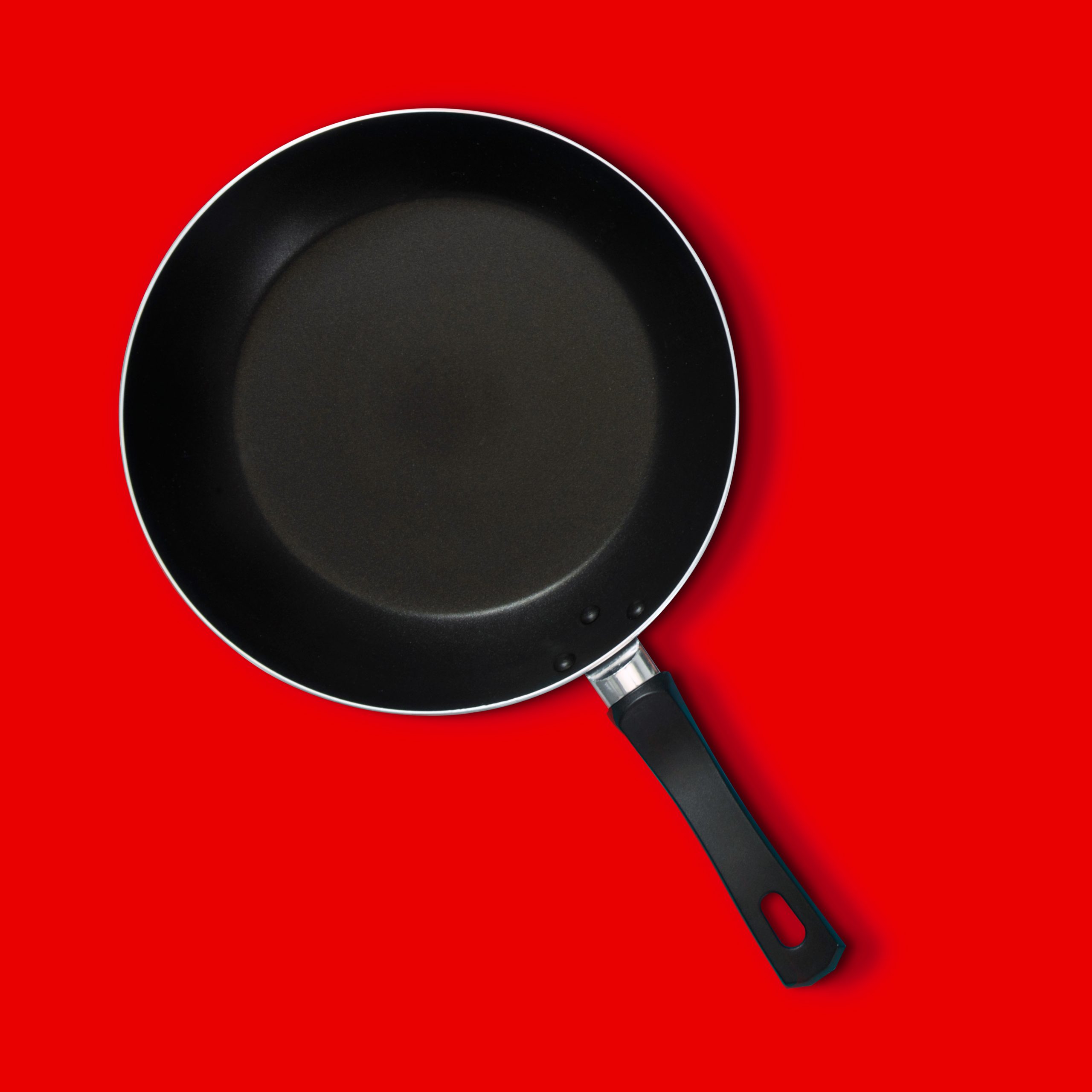 Non-stick pan over red background